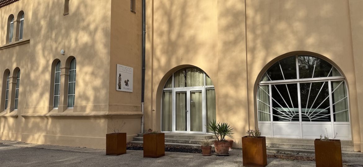 Entrée du Musée spiritain des arts africains à Allex, avec porte vitrée et murs ocre de la Maison Saint-Joseph.